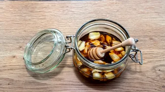 Rețeta bunicii: usturoi pus în miere. Cum se prepară amestecul și de ce este atât de popular