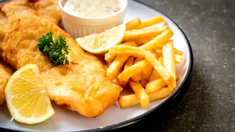 Motivul pentru care, în unele restaurante, preparatul „fish and chips” e servit în ziare