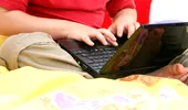 A stat cu laptopul pe abdomen până la 8 ore pe zi. Ce este „sindromul pielii prăjite” și cum poate apărea