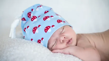 De ce nu e bine ca bebelușul să doarmă cu căciulița pe cap. Avertismentul medicilor: Temperatura prea mare din cameră poate duce la sindromul morții subite a sugarului
