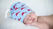 De ce nu e bine ca bebelușul să doarmă cu căciulița pe cap. Avertismentul medicilor: Temperatura prea mare din cameră poate duce la sindromul morții subite a sugarului