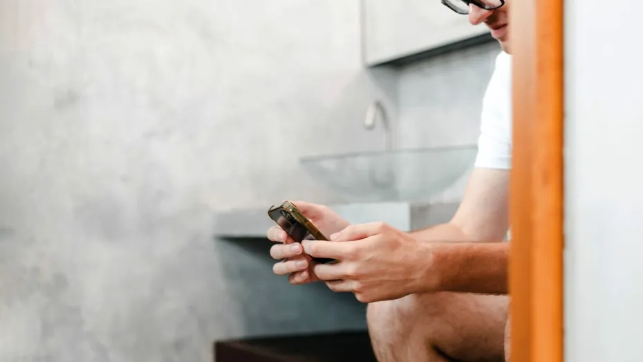 Petreci prea mult timp pe telefon pe toaletă? Poate fi periculos pentru sănătatea ta, avertizează experții