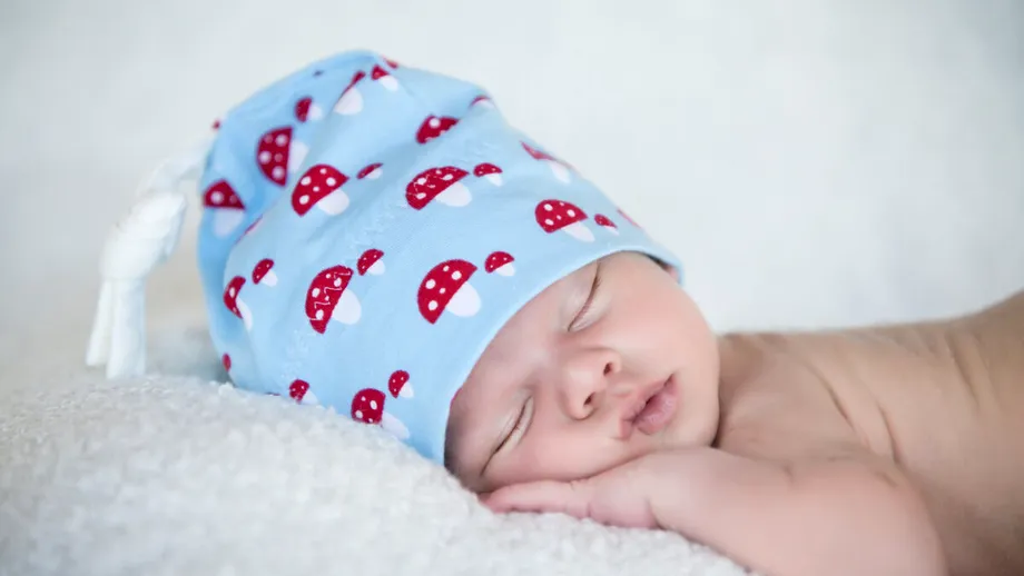 De ce nu e bine ca bebelușul să doarmă cu căciulița pe cap. Avertismentul medicilor: Temperatura prea mare din cameră poate duce la sindromul morții subite a sugarului