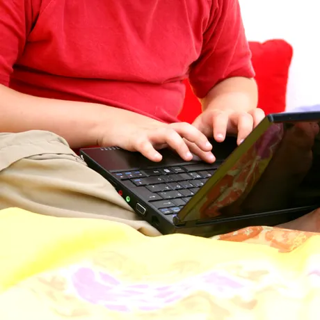 A stat cu laptopul pe abdomen până la 8 ore pe zi. Ce este „sindromul pielii prăjite” și cum poate apărea